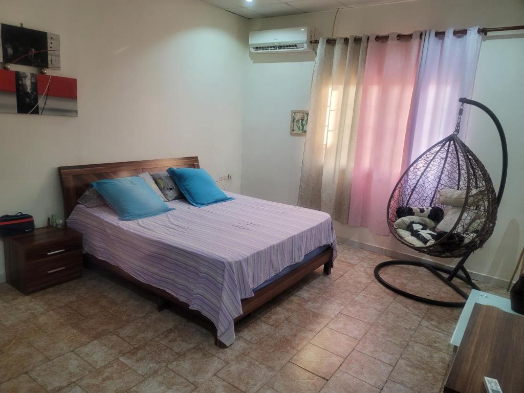 1 dormitorio con cama y columpio en Elyas-House en Yibuti