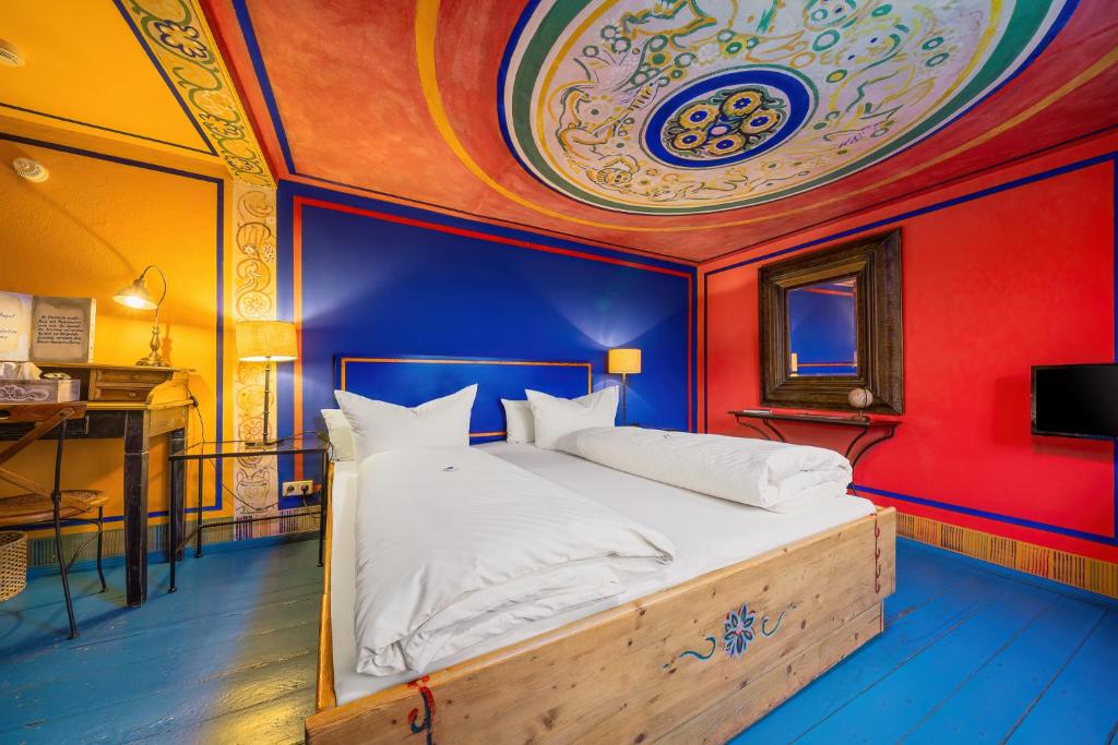 a bedroom with a bed with a blue and red wall at Ristorante e Pensione La Campagnola in Dresden