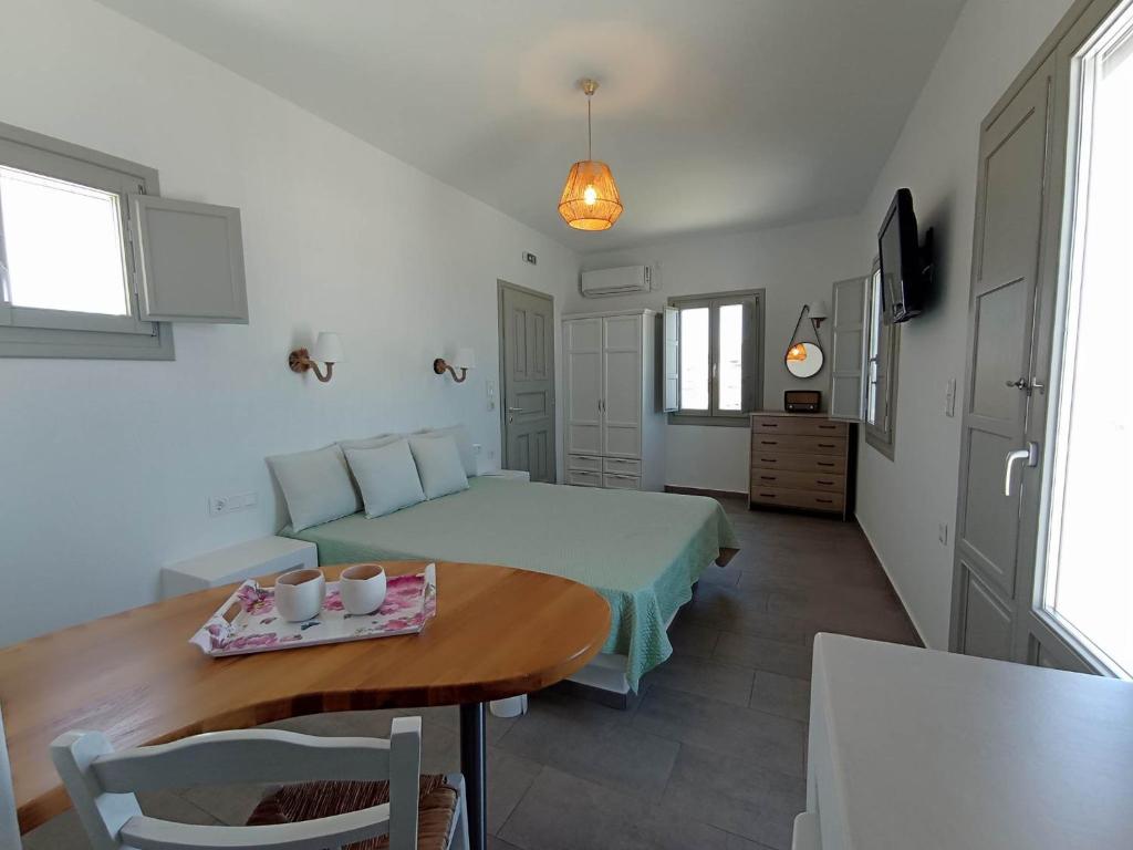 a bedroom with a bed and a table with cups on it at Seascape, apartment with sea view 1 in Áno Meriá