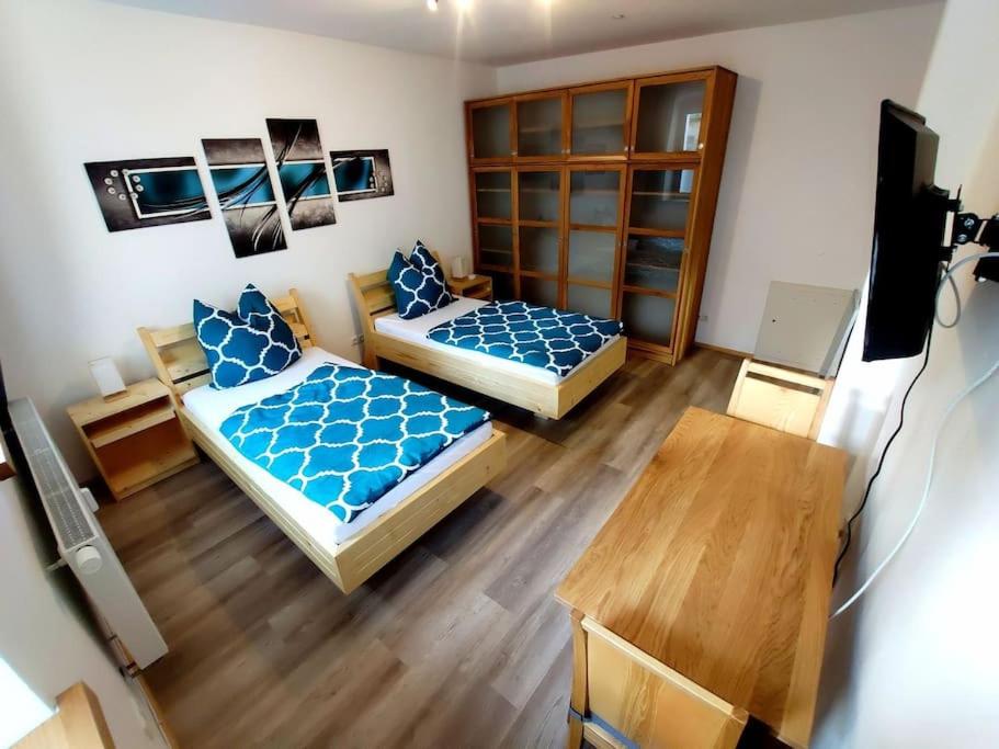 Moderne Wohnung für bis zu 4 Personen في Eschenbach in der Oberpfalz: غرفة بسريرين وطاولة فيها