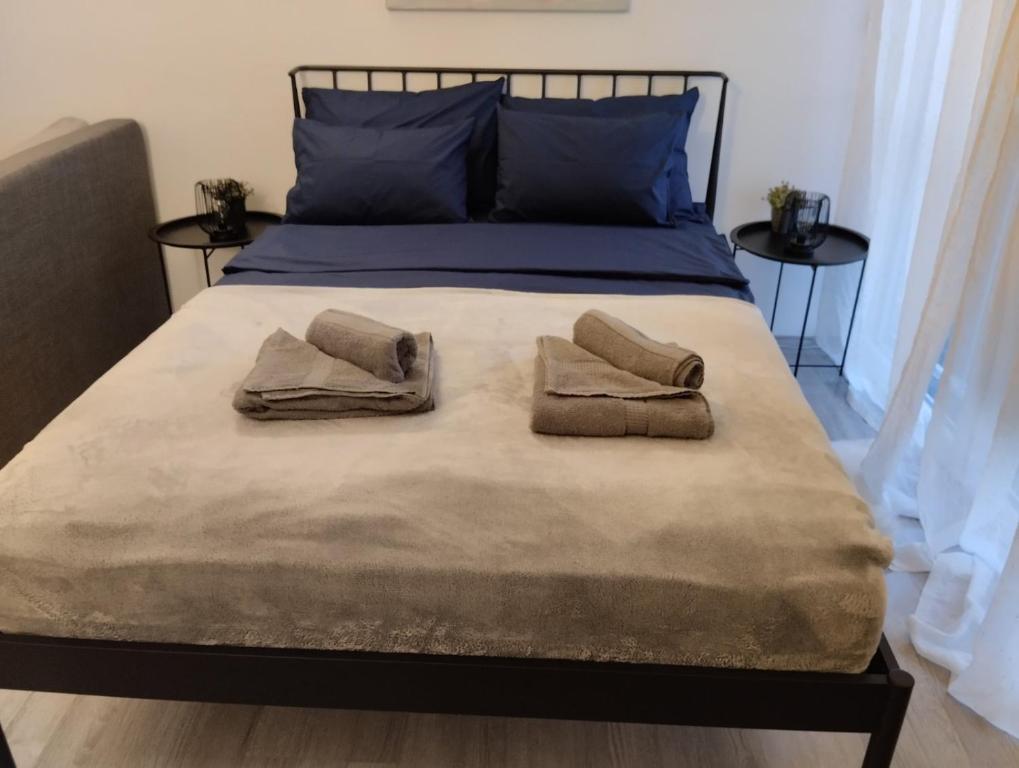 a bed with two pillows and two towels on it at Studio apartman IN Self check in in Osijek