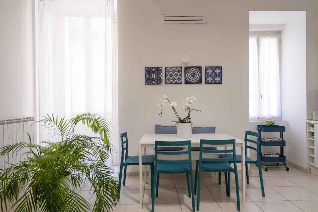 uma sala de jantar com uma mesa e cadeiras azuis em San Liborio Suites em Nápoles
