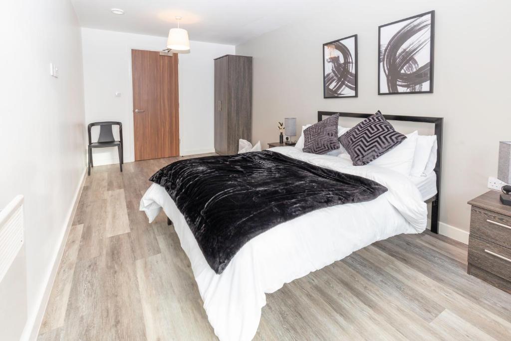 Un dormitorio con una cama grande con una manta negra. en L1 Comfy Escapes - Long Stay Discounts Apply! en Liverpool