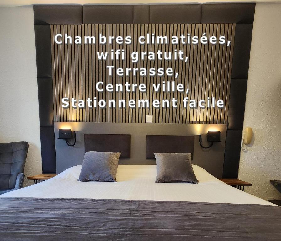 a bedroom with a bed with words on the wall at Cit'Hotel Le Cheval Blanc Cognac Centre in Cognac