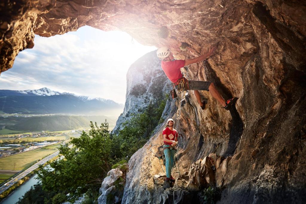 a man climbing a rock formation in a cave at Hotel Garni Löwen in Silz