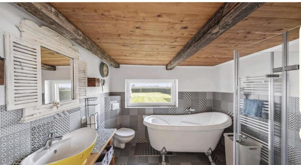 La salle de bains est pourvue d'une baignoire, de toilettes et d'un lavabo. dans l'établissement Ferienhaus nahe Krautsand, à Drochtersen