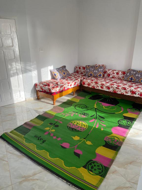 un soggiorno con divano e tappeto verde di Vacancia a Douar Chaïb Rasso