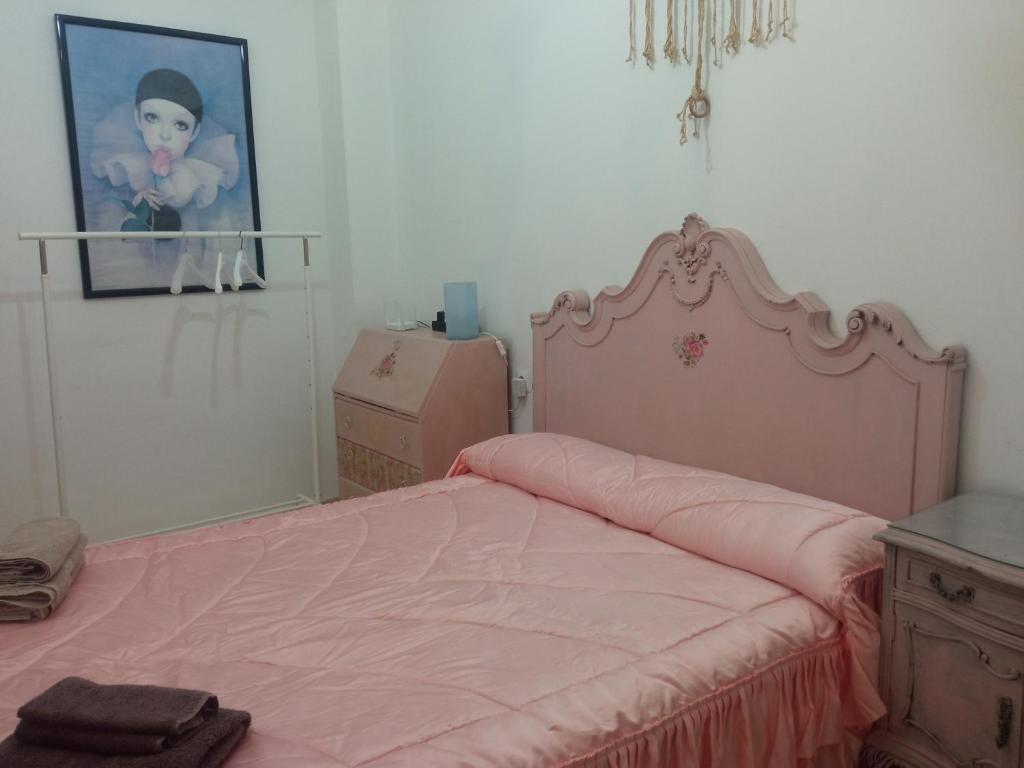 a bedroom with a pink bed and a picture on the wall at Habitación centro Gandia in Gandía