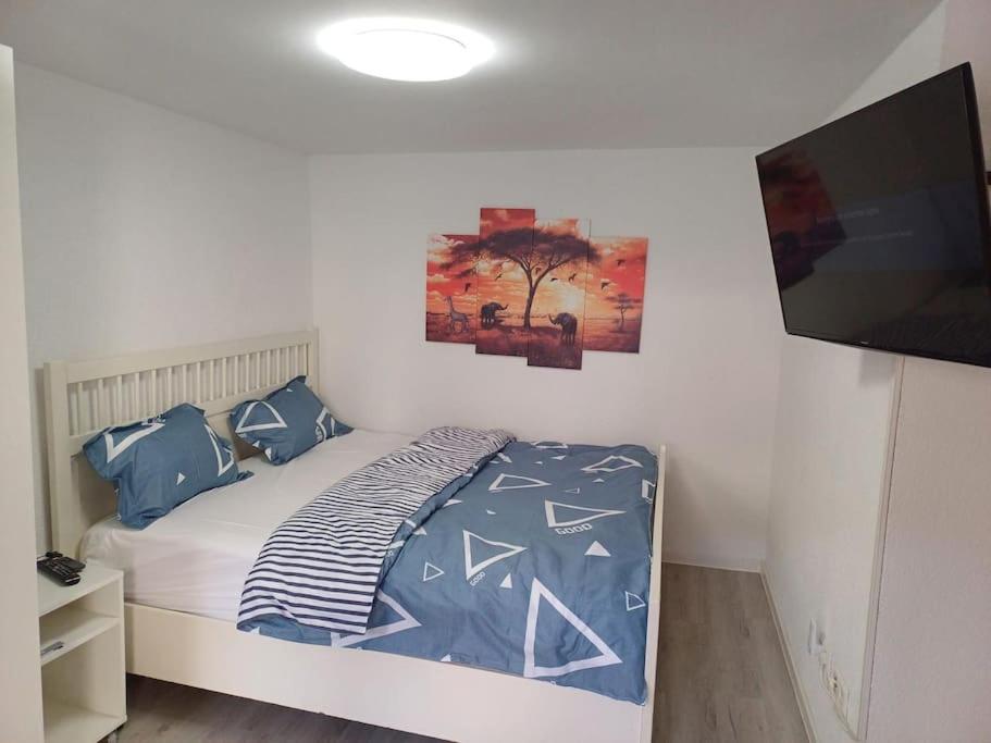 a bedroom with a bed and a flat screen tv at wie zu Hause in Ludwigsburg