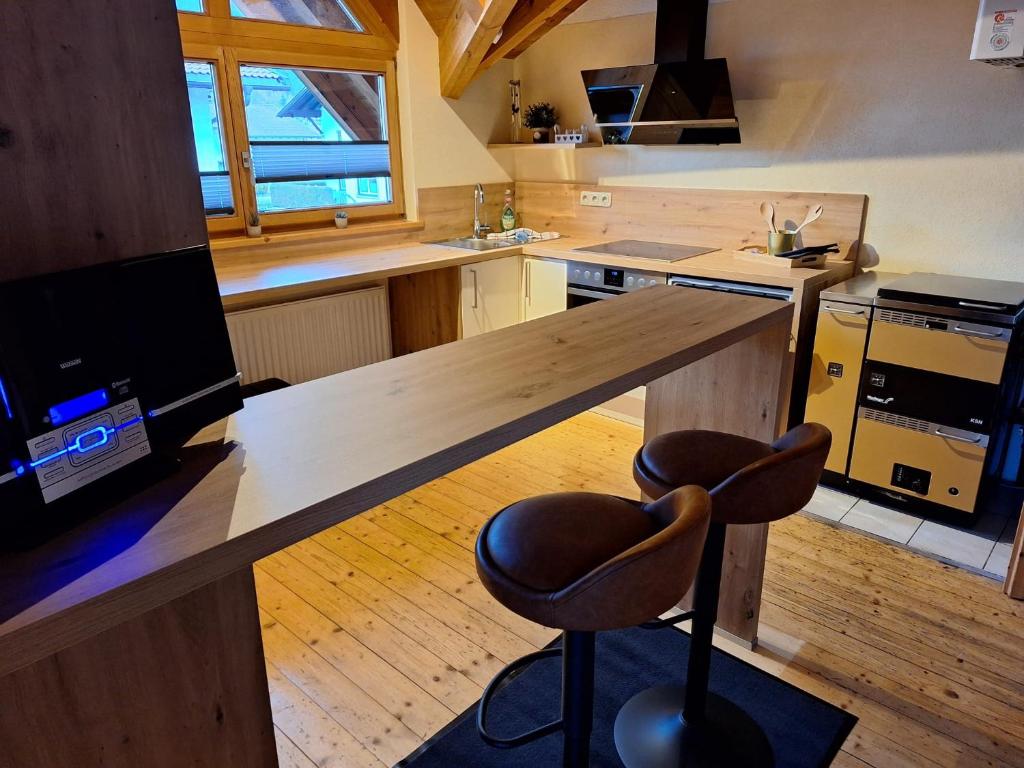 a kitchen with a large wooden counter with a bar at Lechapart Wagner in Reutte