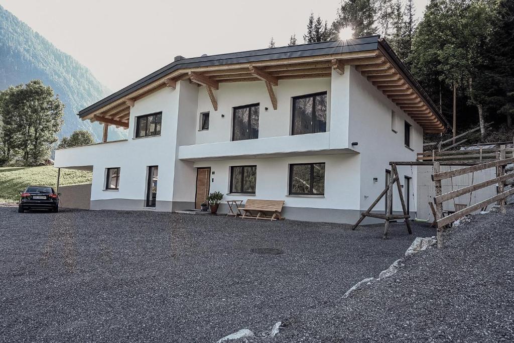 una casa bianca con un'auto parcheggiata davanti di Alpin 1100 a Steeg