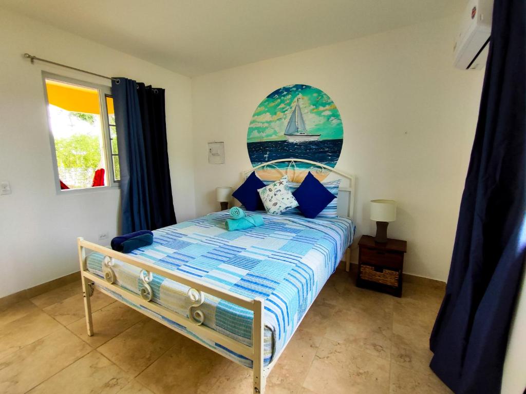 Las Catalinas Coronado في بلايا كورونادو: غرفة نوم مع سرير مع شراع على الحائط