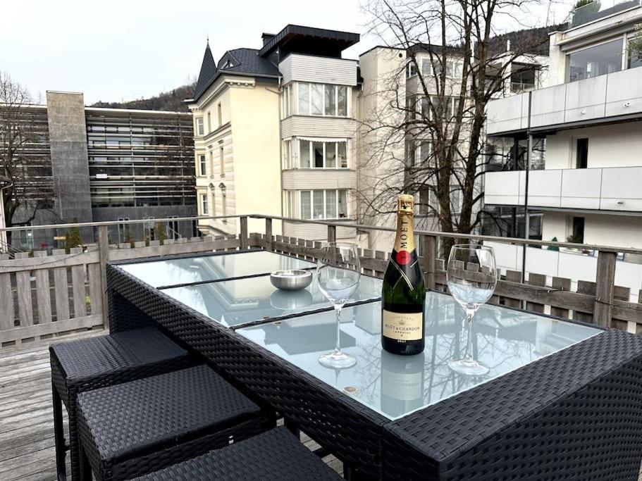 a bottle of wine and two glasses on a table at Maisonette-Apartment mit großer Terrasse im Zentrum von Bregenz in Bregenz