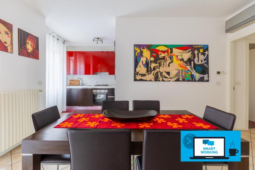 a dining room table with chairs and a painting on the wall at Casa Pibe de oro Bologna Fiera in Bologna