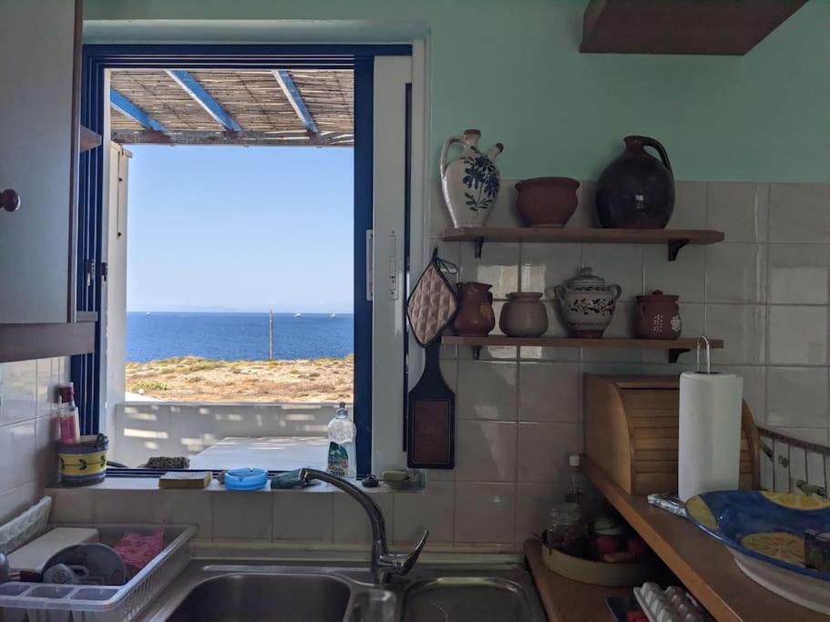 une cuisine avec une fenêtre donnant sur l'océan dans l'établissement Attic Meltemi, à Cap Sounion