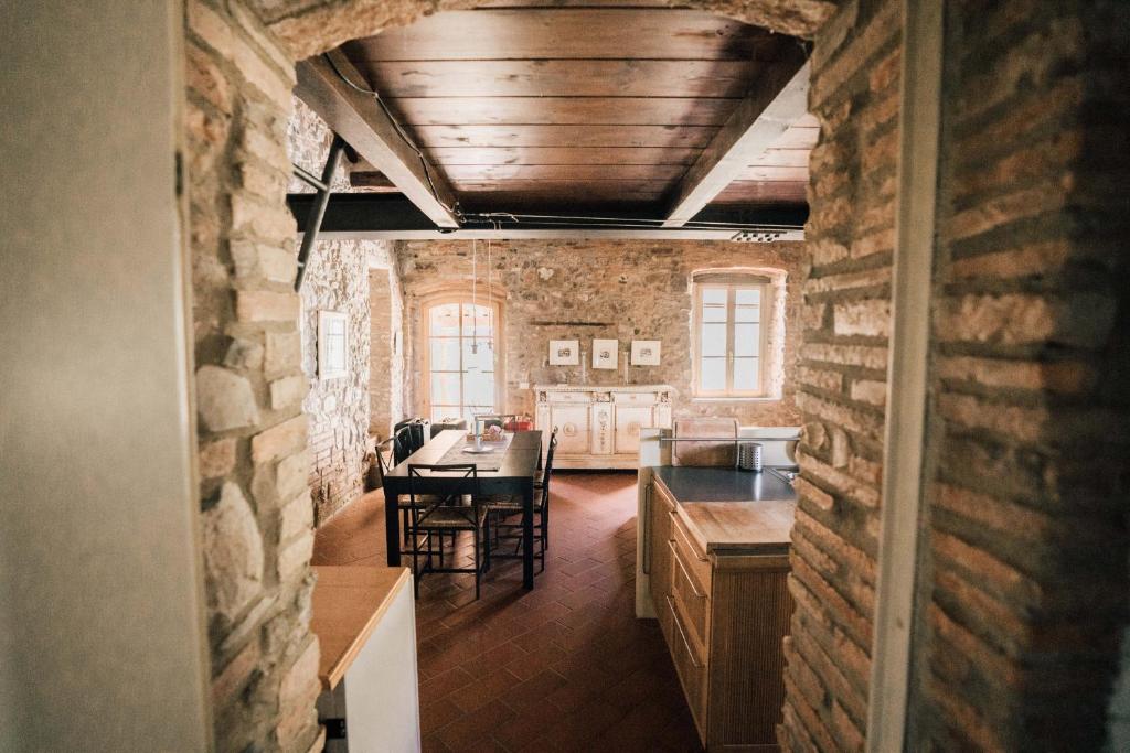 cocina y comedor con pared de ladrillo en Agriturismo Le Valli en Casciana Terme