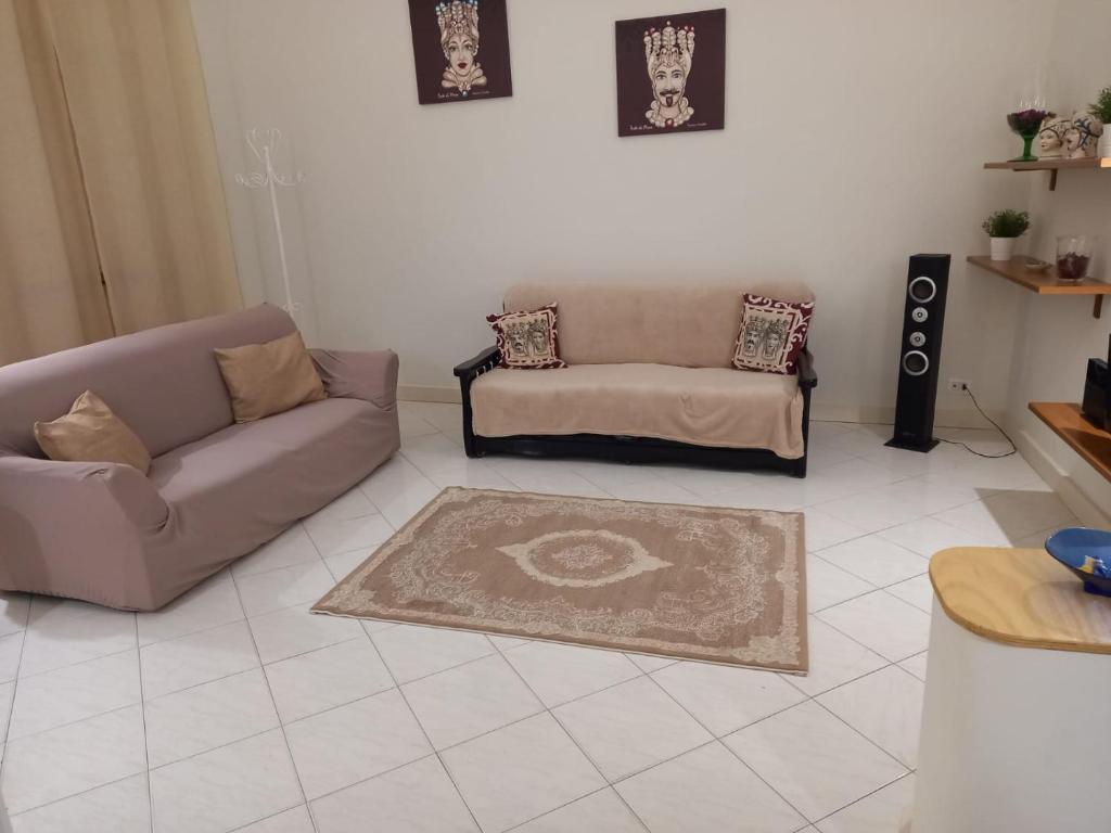 sala de estar con sofá y alfombra en Mosa House, en Aci Castello
