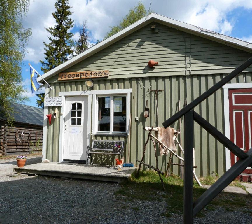 un pequeño cobertizo con una vaca parada fuera de él en Skabram Camping & Stugby, en Jokkmokk