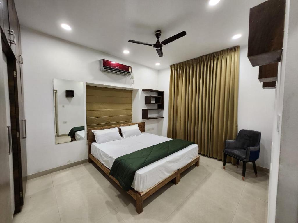 een slaapkamer met een bed en een stoel erin bij Oni Casa in Pune