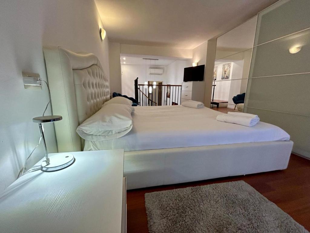 Un dormitorio con una gran cama blanca y una mesa de cristal en Kibilù - Via Tolmezzo - Ospedale San Raffaele - Stazione di Lambrate, en Milán