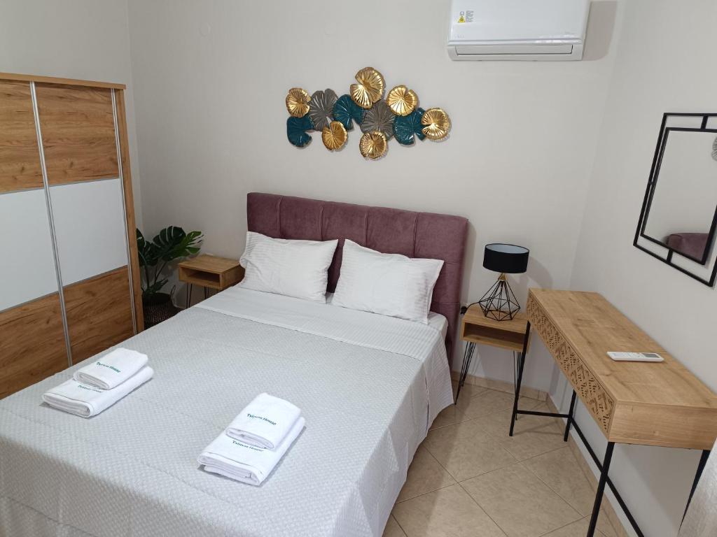 a bedroom with a bed with two towels on it at Tsimas House in Potamia