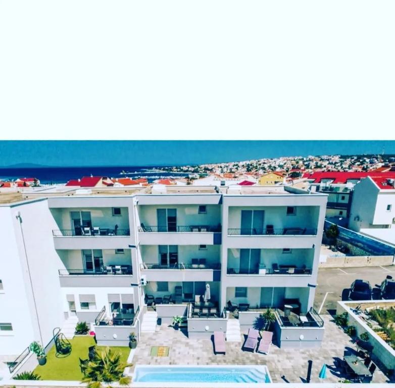 an aerial view of a white building with a pool at Apartments Pool Villa Maria, Novalja in Novalja