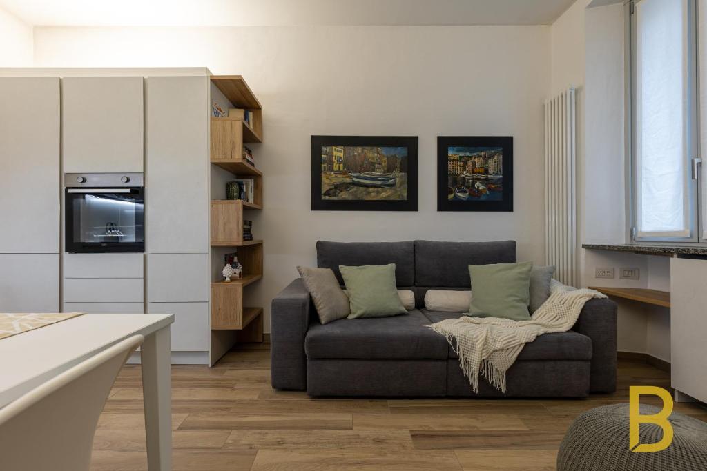 a living room with a couch and a kitchen at BePlace Apartments in Gioia in Milan