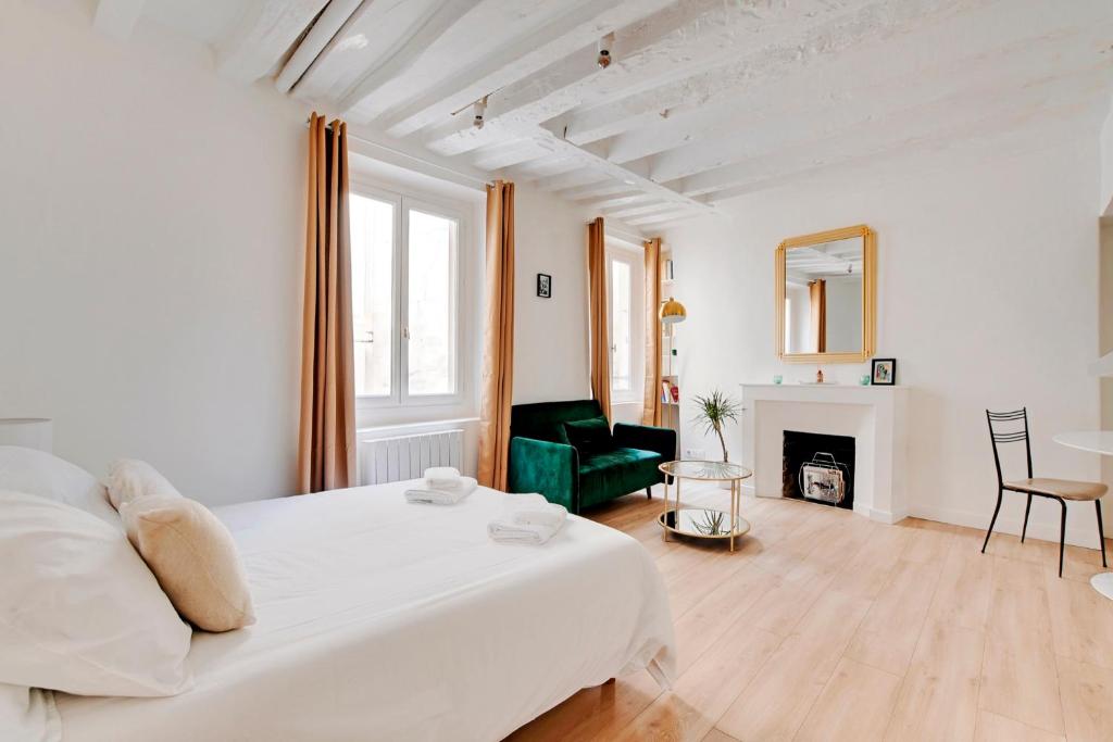 - une chambre blanche avec un grand lit et une cheminée dans l'établissement Saint placide cannette, à Paris