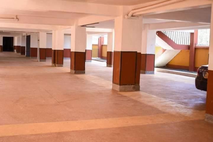 un couloir vide d'un bâtiment avec colonnes et tables dans l'établissement Garden estate thika road, à Nairobi