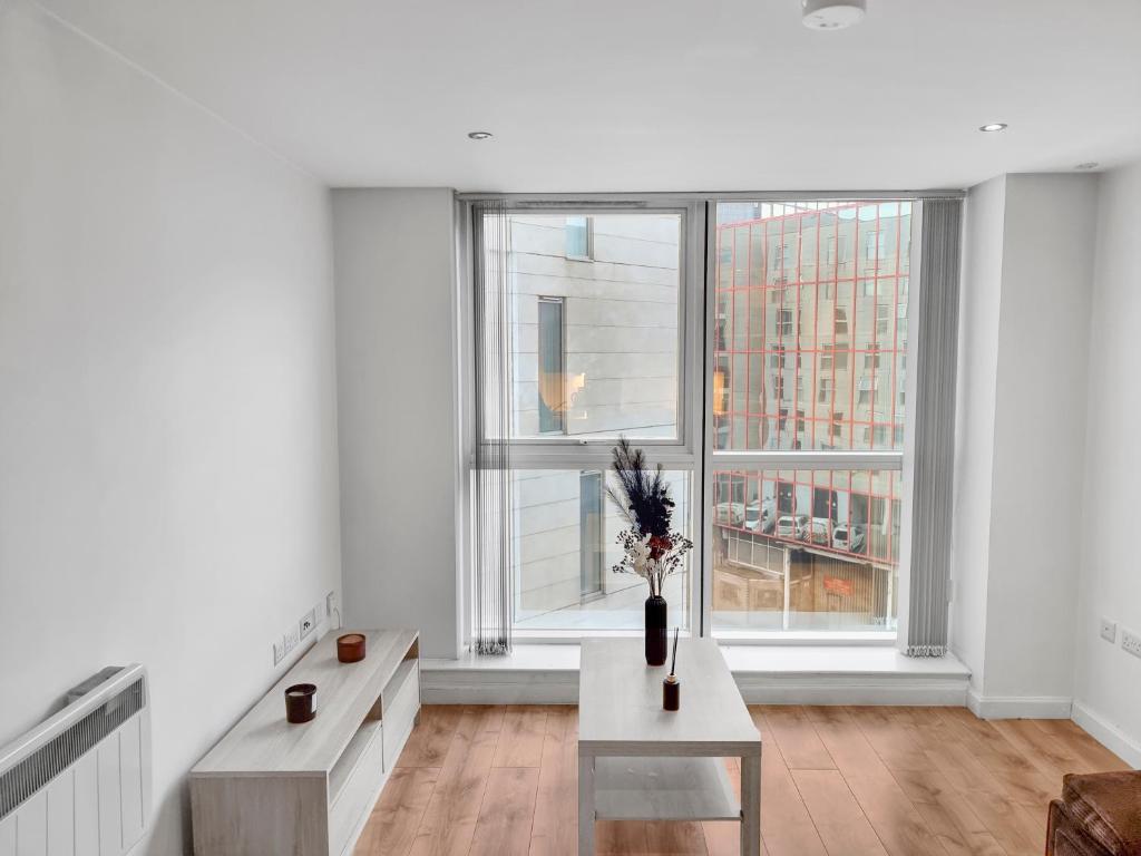 a white room with a table and two windows at 1 Bedroom Apartment in City Centre in Belfast