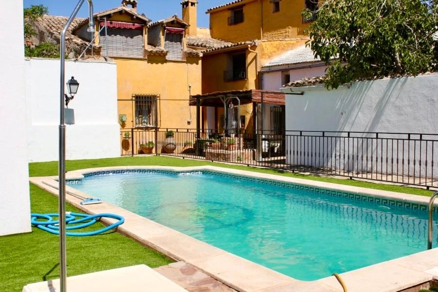 a swimming pool in front of a house at Casa Rural Las Grullas in El Hito