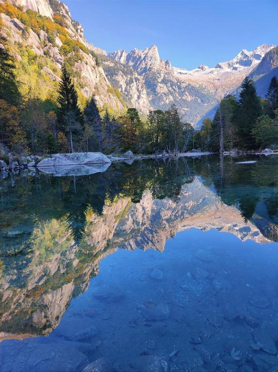 a reflection of a mountain in a body of water at B&B Le Fate Del Lago in Lierna