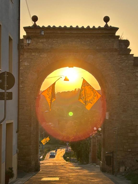 an archway with kites flying in front of the sunset at La casina nel convento in Asciano