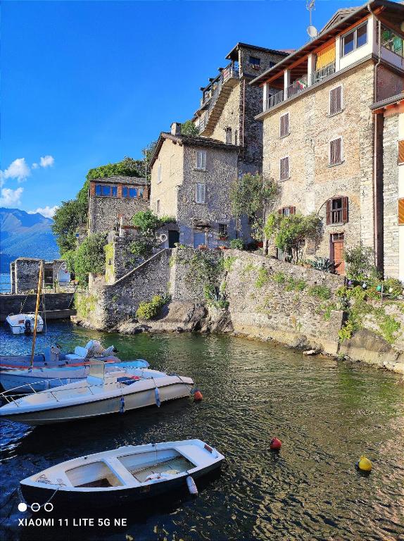 two boats in the water in front of a building at B&B Le Fate Del Lago in Lierna