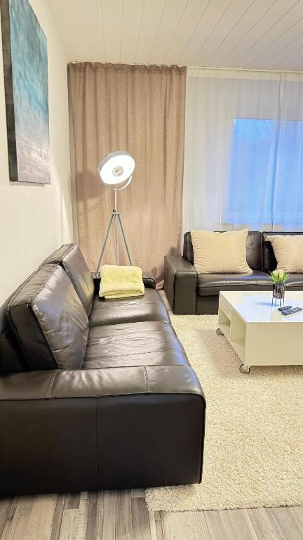 - un salon avec un canapé en cuir et une table dans l'établissement Wohnung im Zentrum von Essen, à Essen