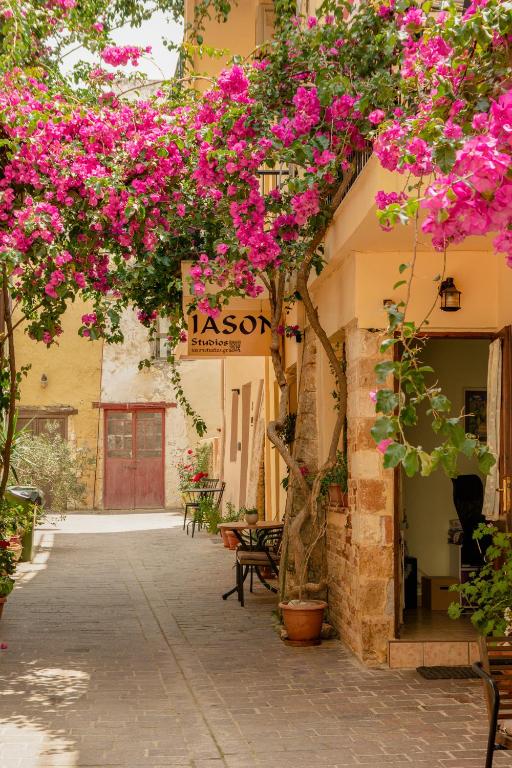 a courtyard with pink flowers on a building at Iason Studios in Chania Town