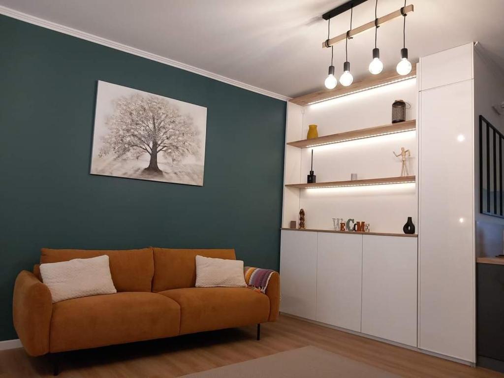 a living room with a couch and a tree on the wall at Appartement de charme 1h de Paris in Coulommiers