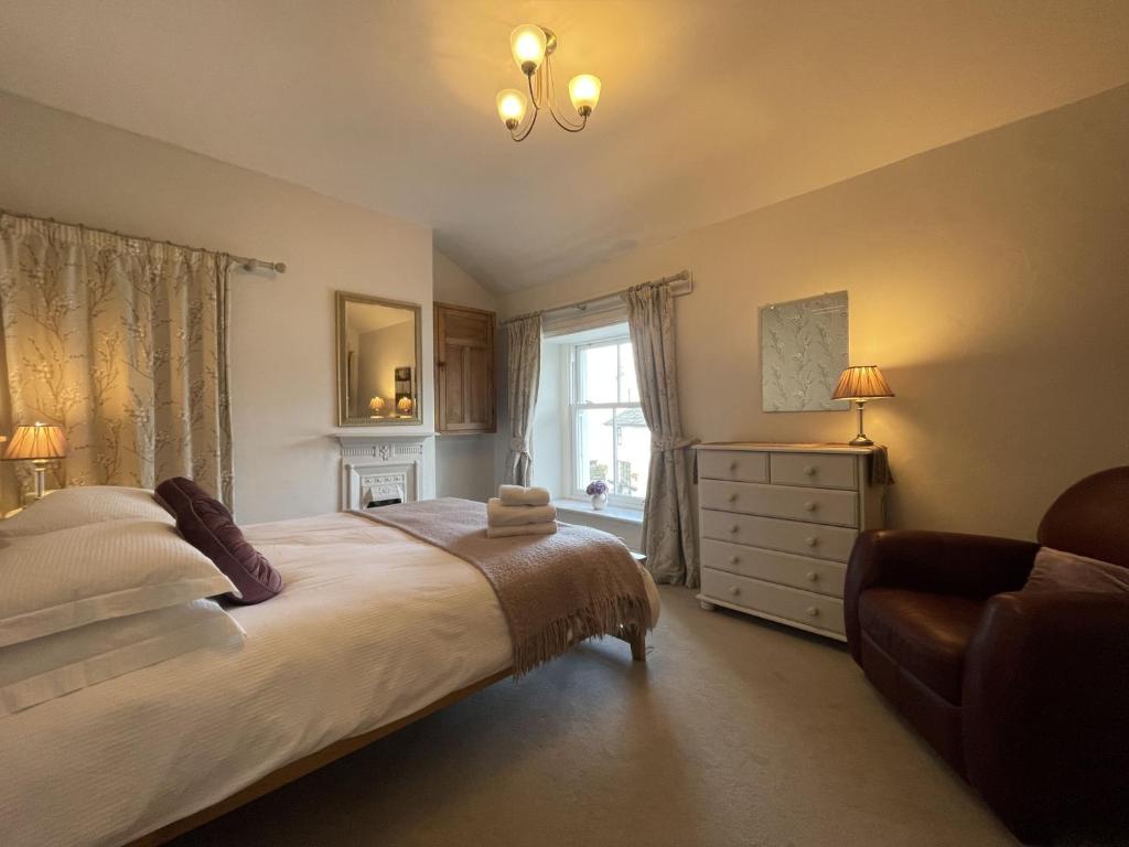 a bedroom with a bed and a dresser and a window at Spa Cottage in Braithwaite