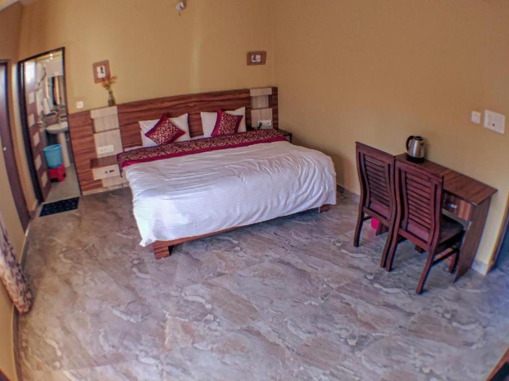 um quarto com uma cama, uma mesa e cadeiras em Old Bhardwaj guest house Inn Bodhgaya em Gaya