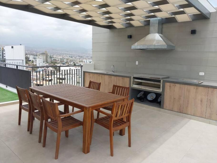 una cucina con tavolo in legno e alcune sedie di Departamento en Cayma ad Arequipa
