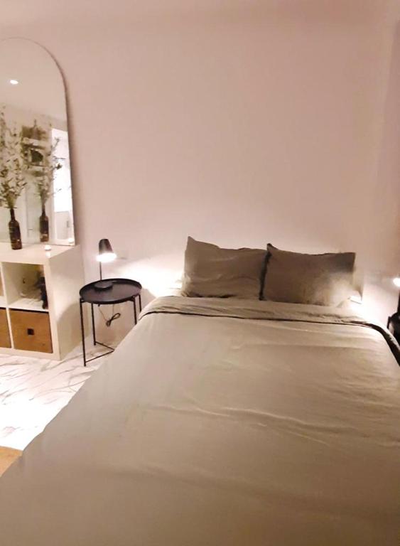 uma cama branca num quarto branco com uma mesa em CASA CARRATALÁ em Benidorm
