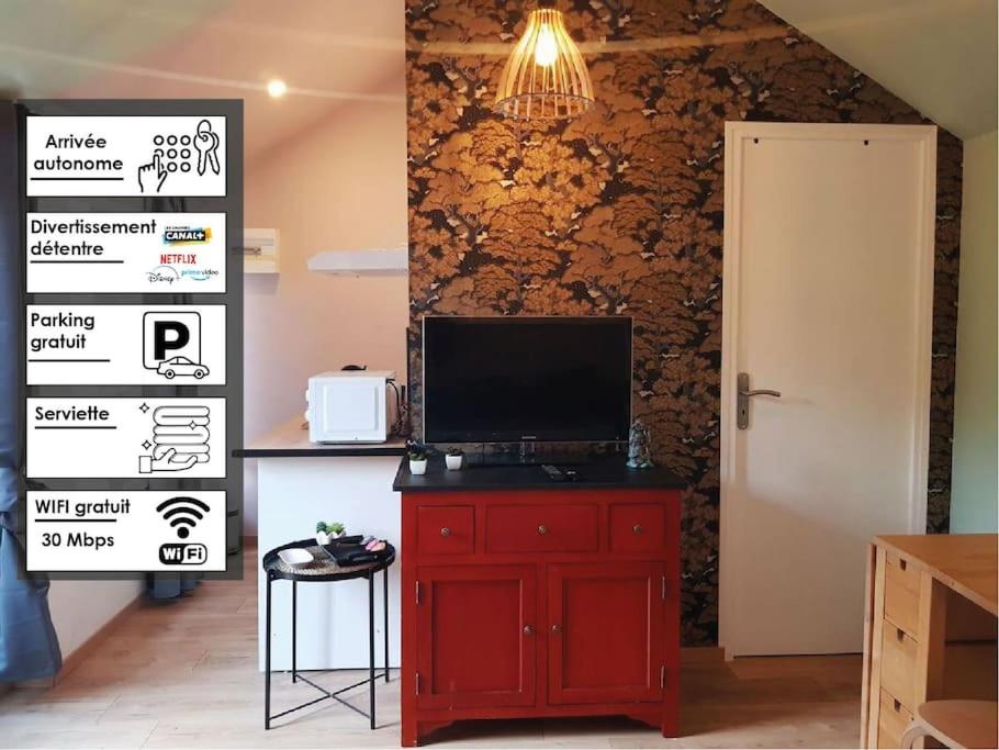 a red cabinet with a television on top of it at Japan House : studio en bois Zen - Wifi - Parking gratuit in Angoulême
