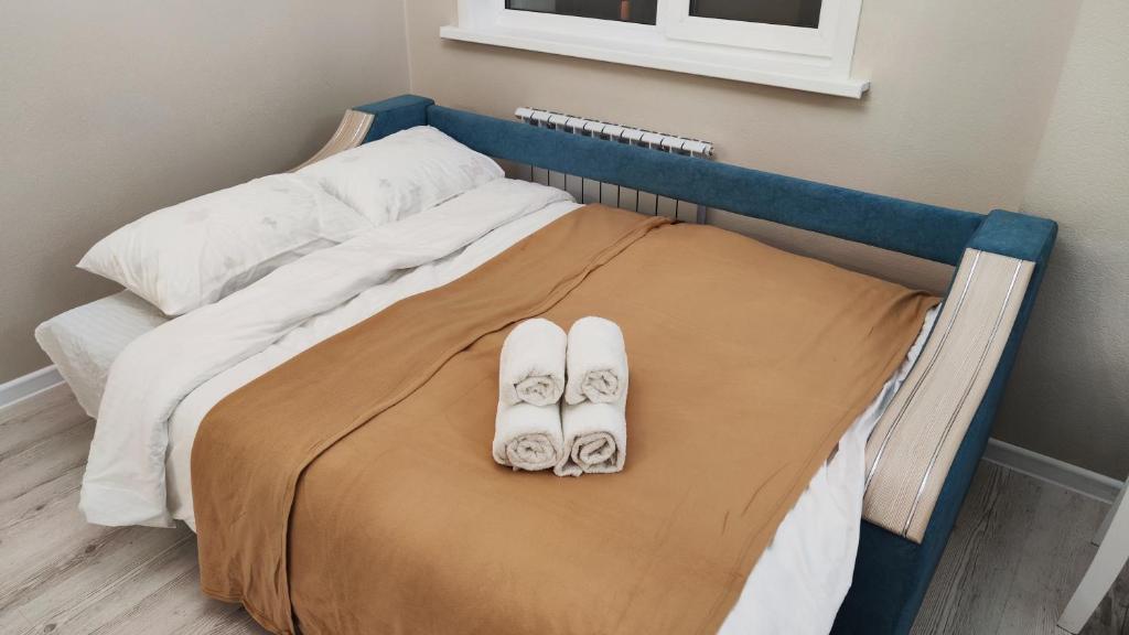 a hospital bed with two pairs of shoes on it at Kamal Apart in Prigorodnyy
