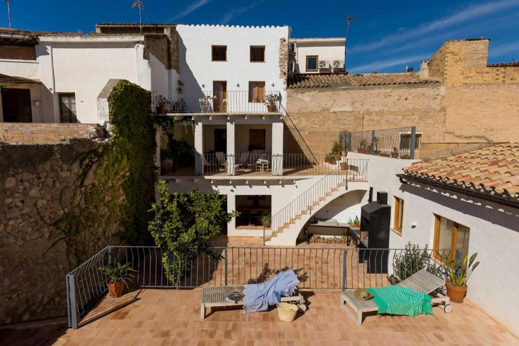 a white house with a patio and a balcony at Casa Rural Boutique Ca Bolo in Pinell de Bray