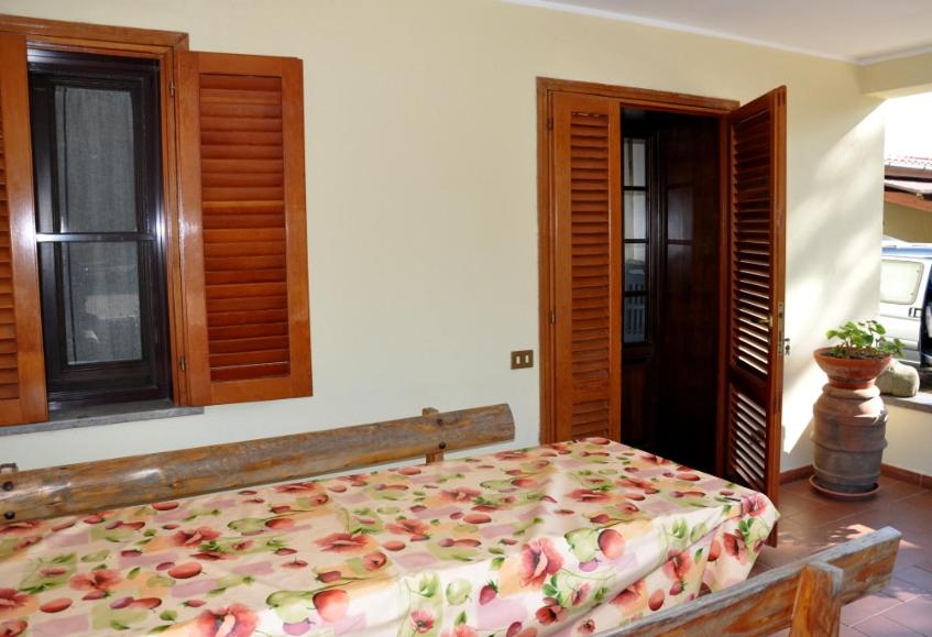 a bedroom with a large bed with a floral bedspread at Appartamenti Pian d'Alma in Punta Ala