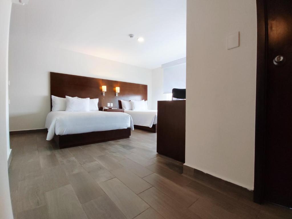 Cette chambre comprend deux lits et un bureau. dans l'établissement Ramada by Wyndham Tampico Centro, à Tampico