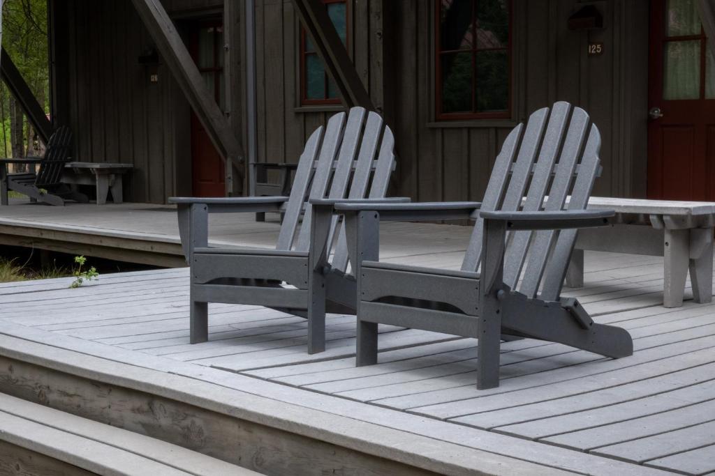 two white chairs and a table on a deck at Sleeping Lady Mountain Resort in Leavenworth