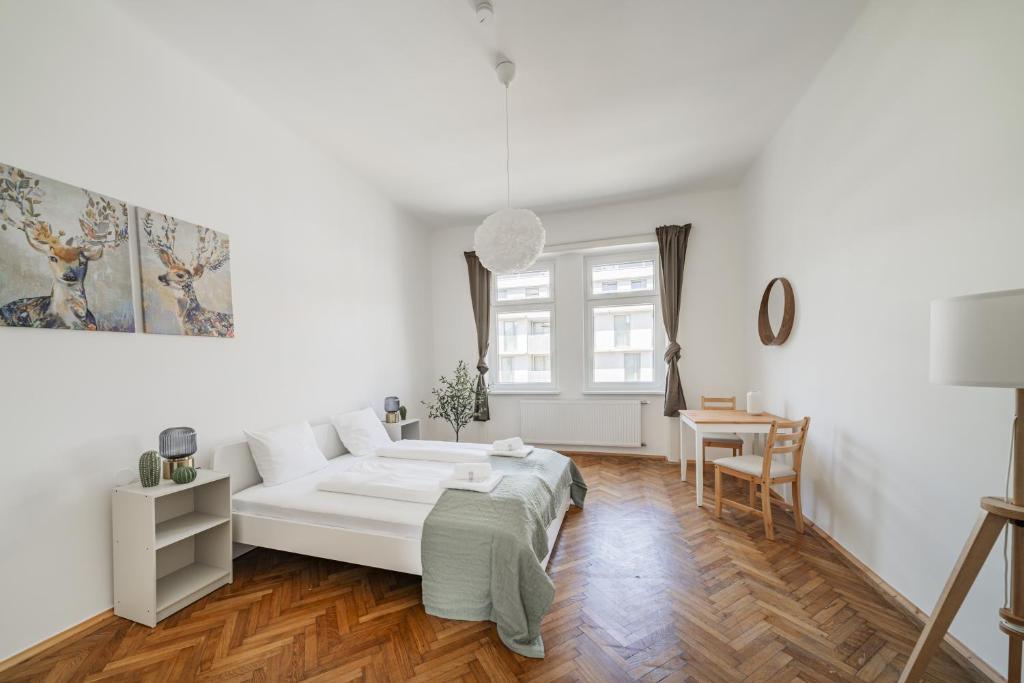 une chambre blanche avec un lit et une table dans l'établissement spacious studio in vienna, à Vienne