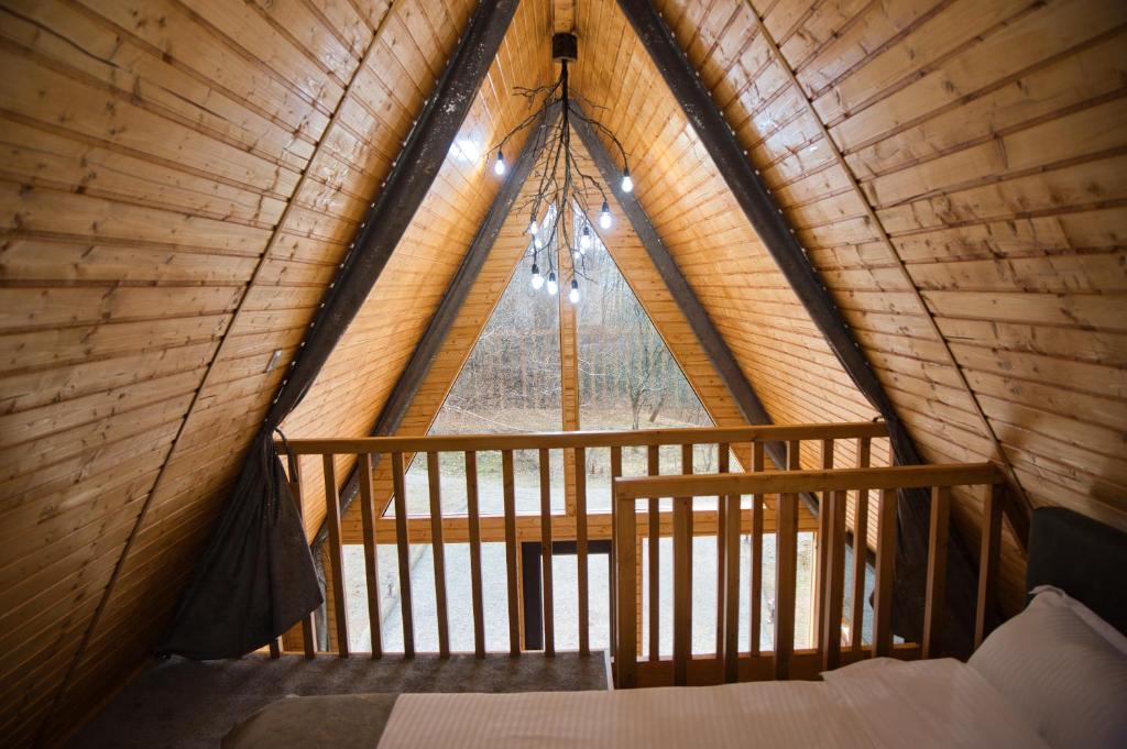 ein Schlafzimmer in einem Baumhaus mit einem großen Fenster in der Unterkunft Cabana A frame Olanesti in Băile Olăneşti