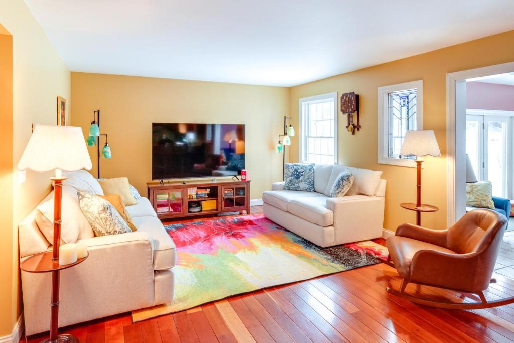 een woonkamer met twee witte banken en een tv bij Colorful Milford Home on 7 Wooded Acres! in Milford